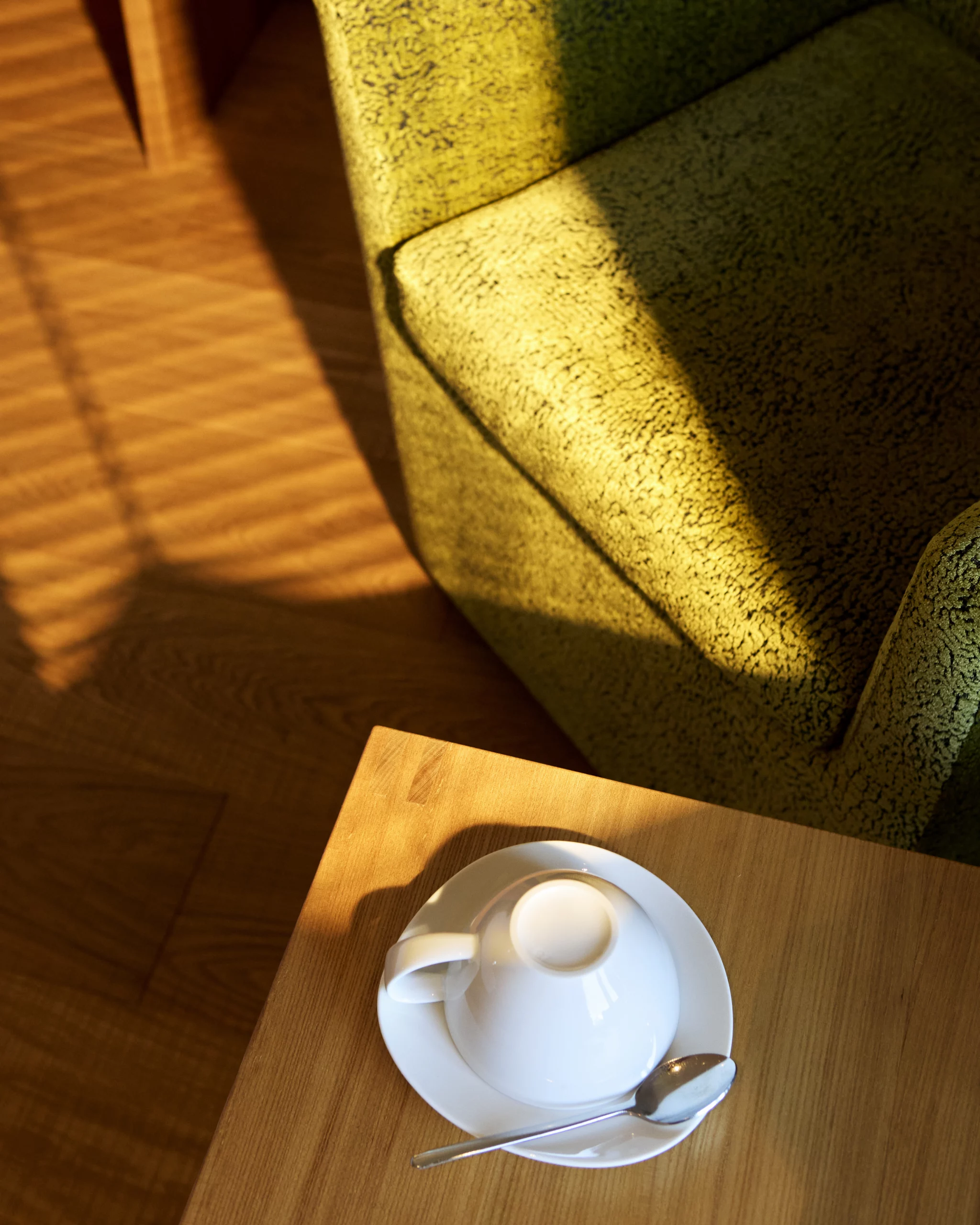 Morgensonne im Hotelzimmer hüllt den Sitz und Leseplatz in warmes Licht und wirkt sehr einladend um einen Kaffee zu trinken.